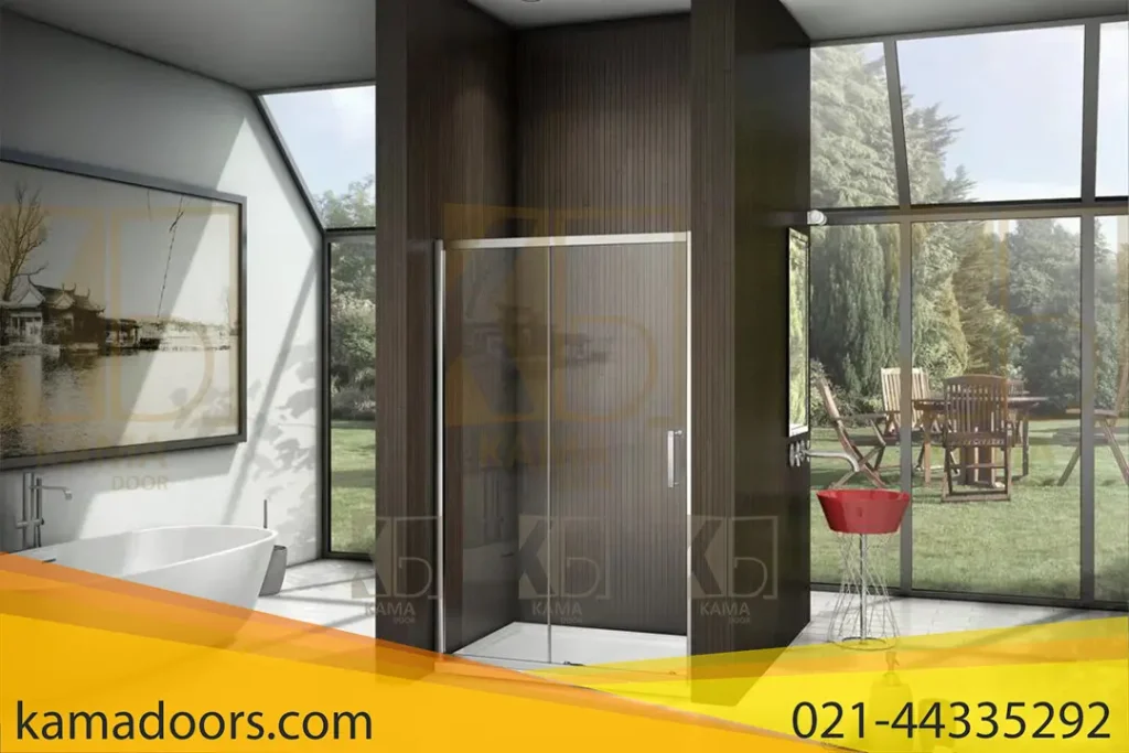 یک حمام مدرن را نشان می‌ دهد که دارای یک وان سفید بزرگ در سمت چپ و یک پارتیشن شیشه‌ ای حمام در مرکز است. پارتیشن های شیشه ای حمام نیز توسط شرکت کامادر طراحی و تولید شده اند. دیوار های حمام از چوب تیره ساخته شده‌اند و کف آن از کاشی‌های سفید پوشیده شده است. در سمت راست، یک سینک قرمز رنگ با پایه فلزی قرار دارد. پنجره‌ های بزرگ در پشت پارتیشن شیشه ای و سینک، نمایی از یک باغ زیبا با میز و صندلی‌ های چوبی را نشان می‌ دهند. همچنین یک تابلو بزرگ با تصویر یک منظره طبیعی بر روی دیوار سمت چپ نصب شده است.