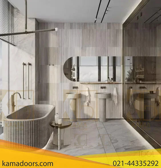 حمام مدرن و بزرگی است که با رنگ‌ های روشن، احتمالاً سنگ مرمر، کف‌ پوش و دیوارهای همسان که دارای شیارهای عمودی است و ظاهری پیچیده را ارائه می‌ دهد، طراحی شده است. ویژگی های برجسته شامل یک وان حمام مستقل با طراحی منحنی منحصر به فرد و یک سطح صاف یکپارچه است که می تواند به عنوان قفسه عمل کند. همچنین یک قسمت روشویی با یک آینه بزرگ وجود دارد که تقریباً به عرض دیوار می رسد. زیر آینه دو سینک با شیرآلات مدرن تعبیه شده است. پالت رنگی خنثی و خاکی است که از رنگ های بژ و چوبی با رنگ روشن تشکیل شده است که فضایی مطبوع و آرام به فضا می بخشد. در یک طرف اتاق، فضای دوش با پارتیشن شیشه ای وجود دارد، اگر چه سر دوش و کنترل ها به طور کامل در این تصویر قابل مشاهده نیستند. به نظر می رسد نور طبیعی از پنجره می آید که در آینه منعکس می شود و به اتاق روشنایی می بخشد.