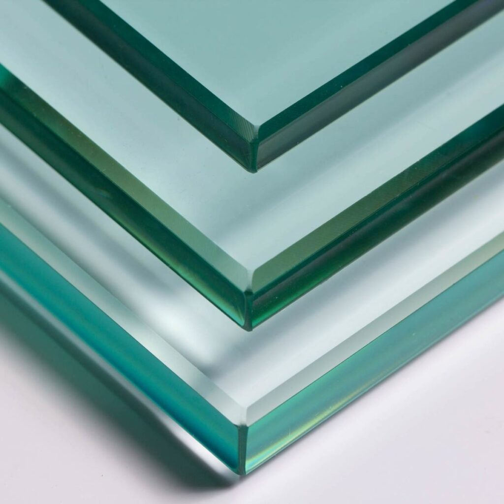 پشته ای از ورق های شیشه ای را با ضخامت های مختلف نشان می دهد که از بالا به پایین مرتب شده اند. این شیشه کمی مایل به سبز است که به دلیل وجود آهن، مشخصه انواع خاصی از شیشه فلوت است. لبه‌ های ورق‌های شیشه صاف و صیقلی هستند که نشان می‌دهد آن‌ها تمام شده و آماده استفاده در ساختمان‌سازی، مبلمان یا سایر مواردی هستند که نیاز به شیشه با کیفیت بالا دارند. پس زمینه یک رنگ روشن و یکدست است که باعث افزایش وضوح و تفاوت رنگ بین لبه ها و سطوح اصلی ورق های شیشه ای می شود.