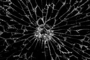 شیشه های سکوریت شکسته ای را نشان می دهد که به نظر می رسد که شکستگی از یک نقطه مرکزی منشأ گرفته است، با ترک های متعددی که در همه جهات به بیرون تابش می کنند و الگویی شبیه به شبکه ایجاد می کنند. قطعات شیشه سکوریت شکسته در اندازه و شکل متفاوت هستند و لبه های تیز آن قابل مشاهده است. پس زمینه مشکی با کیفیت بازتابنده و شفاف شیشه در تضاد است و بر بافت شکسته و جزئیات پیچیده ترک ها تأکید می کند. ظاهر کلی به شکل شکستگی، تکه تکه شدن و تخریب است.