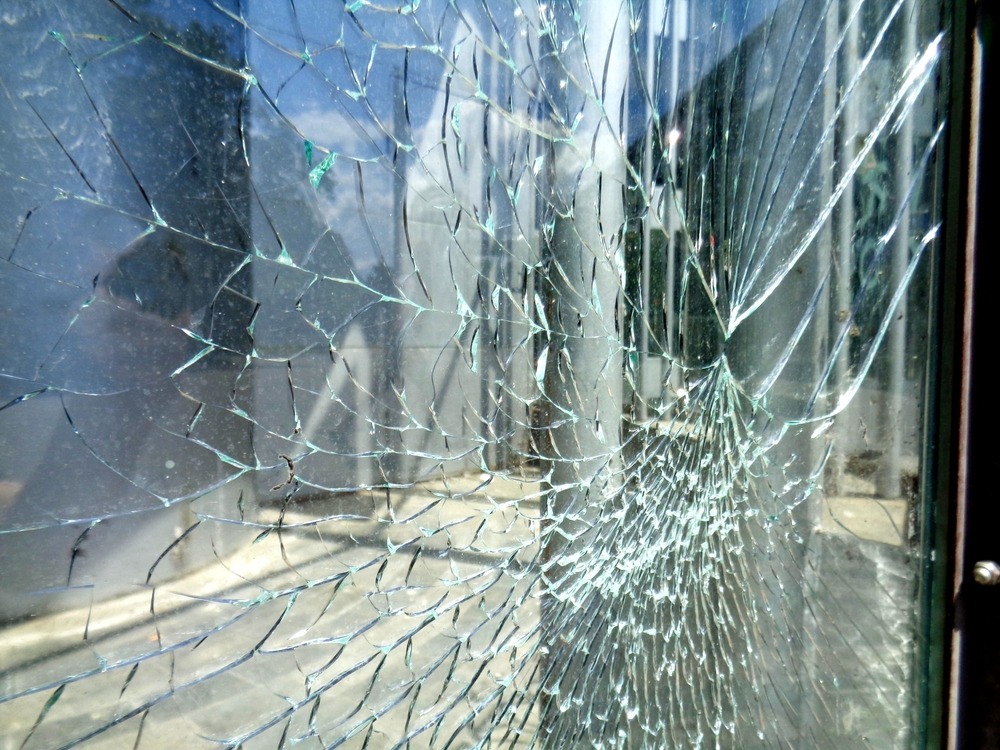 شیشه ی پنجره ای است که ترک خورده و نزدیک از که فرو بریزد. این پنجره شامل بک فریم آلومینیومی نیز می باشد که در سمت راست شیشه یک دستگیره ی فلزی آهنی به درب متصل شده است. در قسمت های بالایی شیشه ترک ها شامل قطعات بزرگتری می باشند و قسمت های پایینی نیز شامل ترکات ریزتری می باشد. از پشت این شیشه سکوریت ترک خورده منظره ای دیده می شود. این منظره کاملا واضح نیست.