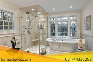 یک حمام بزرگ و روشن است که با پنجره‌ های بزرگی که نور طبیعی را فراهم می‌ کنند، روشن شده است. یک وان حمام سفید بزرگ با جلوی خمیده و اتصالات در سمت راست وان قرار دارد. یک محفظه دوش با دیوارهای شیشه‌ ای کامادر در سمت چپ وان دیده می‌ شود که دوش و کنترل‌ ها بر روی دیوار داخلی نصب شده‌ اند. کف و دیوارها با کاشی‌ های رنگ روشن پوشیده شده‌ اند و حاشیه‌ های تزئینی جزئیات بیشتری به فضا اضافه می‌ کنند. یک میز کوچک در کنار وان حمام قرار دارد که حوله و لوازم حمام را نگه می‌ دارد. در مقابل منطقه دوش، گیاهی در گلدان سیاه روی یک صندلی کوچک یا پایه قرار دارد. در سمت چپ، سبدی وجود دارد که حوله را نگه می‌ دارد که به نظر می‌رسد سبد لباسشویی یا سطل زباله باشد. روی دیوار مقابل پنجره‌ ها، آثار هنری قاب‌بندی شده یا متنی وجود دارد اما از این فاصله به اندازه کافی واضح نیست که بتوان آن را خواند.