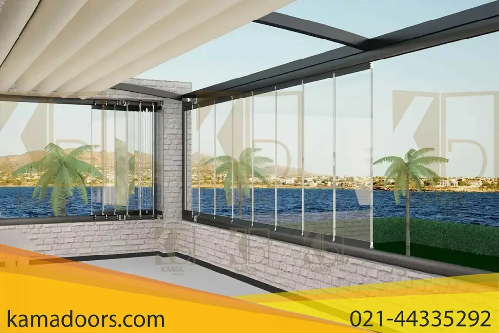 یک فضای داخلی مدرن را با یک شیشه بالکنی بزرگ نشان می دهد که منظره ای خیره کننده از یک چشم انداز ساحلی را ارائه می دهد. شیشه بالکنی کامادر به محیط تراس جلوه منحصر به فردی بخشیده است. این اتاق دارای دیوار های سفید و سقف سفید تا حدی پوشیده شده است که به عنوان بخشی از معماری ساختمان به سمت بیرون کشیده شده است. کفپوش به رنگ روشن و احتمالاً کاشی کاری شده یا بتن صیقلی است. در سمت چپ، مبلمان در فضای باز وجود دارد، از جمله حداقل یک صندلی قابل مشاهده، که نشان می دهد این ممکن است یک منطقه بالکن یا پاسیو باشد.