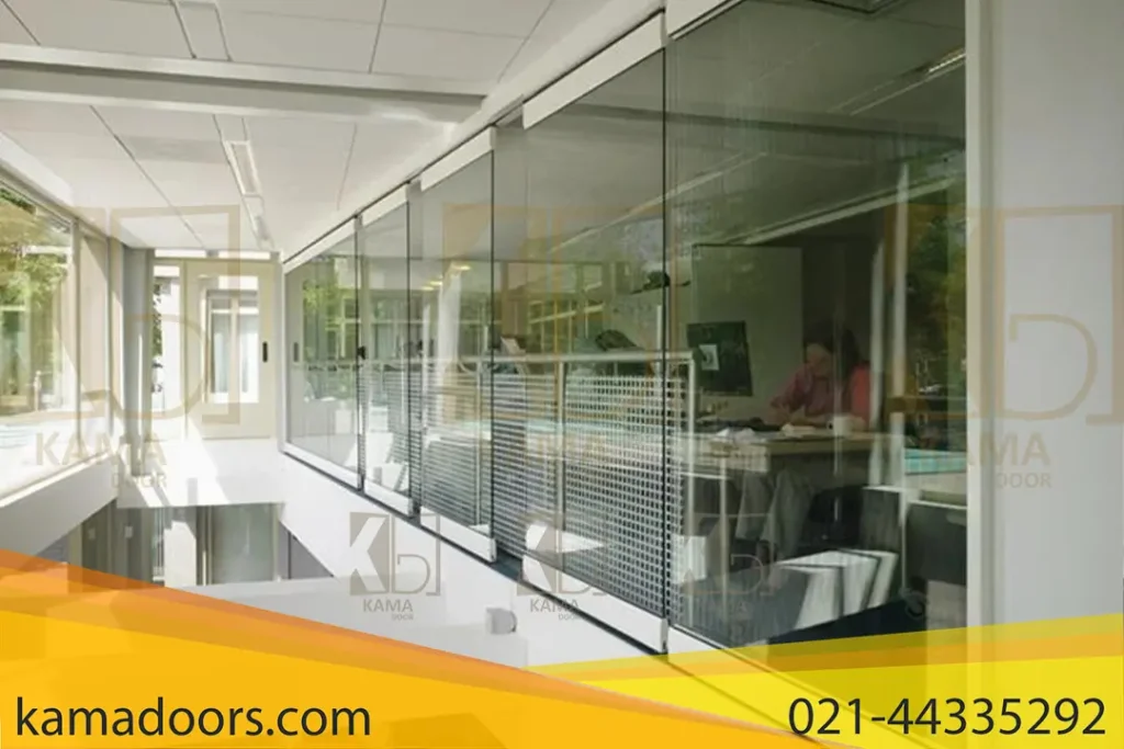 یک فضای داخلی مدرن را نشان می‌ دهد که شامل یک راهرو با پارتیشن های فولدینگ است. در سمت راست تصویر، یک اتاق با پارتیشن های فولدینگ کامادر مشاهده می‌ شود که افراد در حال کار هستند. طراحی این فضا به گونه‌ ای است که نور طبیعی به خوبی وارد می‌ شود، و این باعث ایجاد محیطی روشن و باز می‌ شود. استفاده از شیشه در این طراحی جذابیت خاصی به فضا بخشیده است.